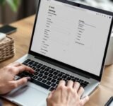 Person managing Shopify settings on a laptop.